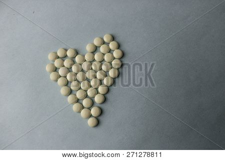Small Medical Pharmaceptic Round Pills, Vitamins, Drugs, Antibiotics In The Form Of A Heart On A Bla