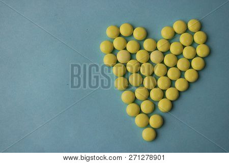 Small Medical Pharmaceptic Round Yellow Pills, Vitamins, Drugs, Antibiotics In The Form Of A Heart O