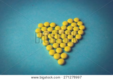 Small Medical Pharmaceptic Round Yellow Pills, Vitamins, Drugs, Antibiotics In The Form Of A Heart O