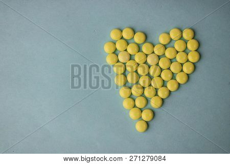 Small Medical Pharmaceptic Round Yellow Pills, Vitamins, Drugs, Antibiotics In The Form Of A Heart O