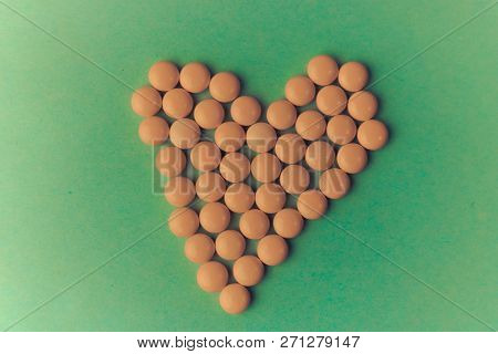 Small Medical Pharmaceptic Round Yellow Pills, Vitamins, Drugs, Antibiotics In The Form Of A Heart O