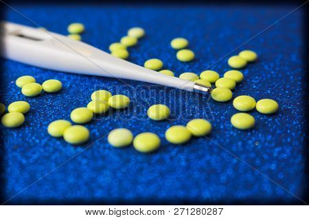 Small Medical Pharmacetic Round Tablets, Vitamins, Drugs And Electronic Digital Thermometer On A Blu