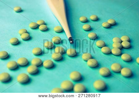 Small Medical Pharmacetic Round Tablets, Vitamins, Drugs And Electronic Digital Thermometer On A Blu