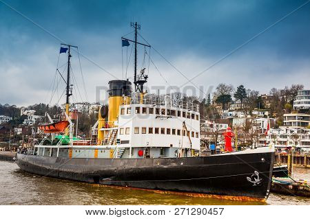 Ship And Buildings On The Banks Of The Elbe River In Hamburg In A Cold End Of Winter Day
