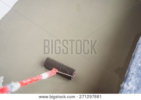 Plasterer During Floor Covering Works With Self-levelling Cement Mortar