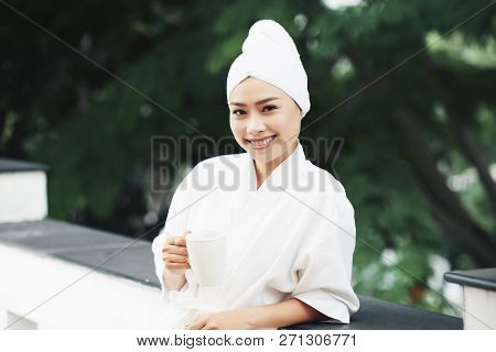 Smiling Beautiful Vietnamse Woman In Bathrobe Standing Outdoors With Cup Of Coffee