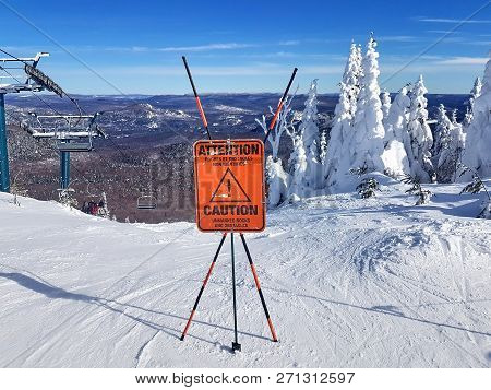 Caution Sign And Warning On A Ski Resort About Unmarked Rocks And Obstacles In The Beginning Of A Tr