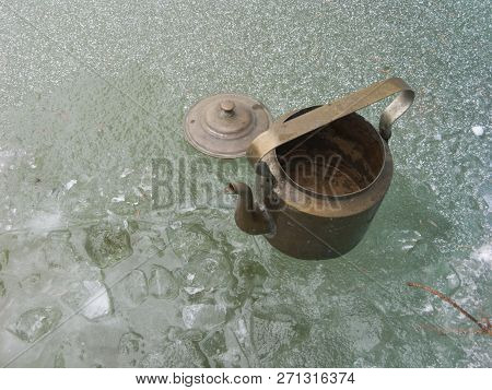 Vintage Bronze Kettle Placed Next To Hole In The Ice