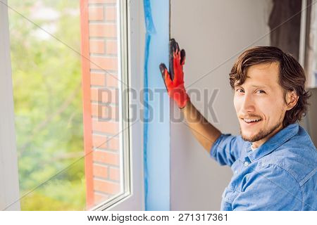 Man In A Blue Shirt Does Window Installation