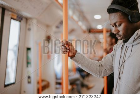 Standing passenger listening to music on the train