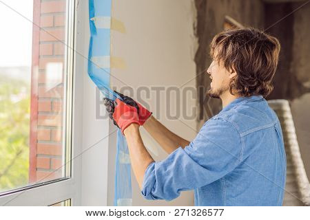 Man In A Blue Shirt Does Window Installation
