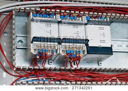 Three Controllers Or Devices Are Fixed In The Electrical Cabinet. They Are Connected To Electrical W