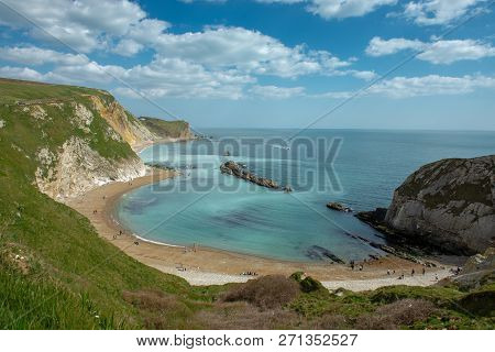 View Of The Lulworth Cove Landscape With Limestone Cliffs In Dorset, United Kingdom