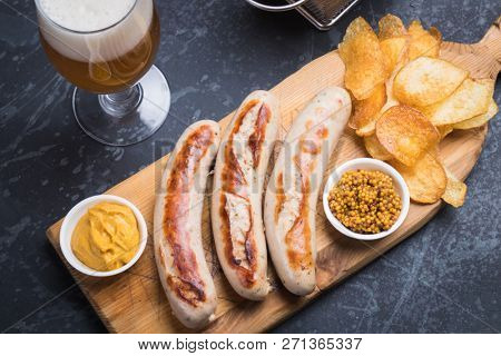 Grilled german sausages with mustard and fried potato chips