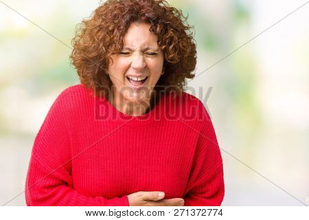 Beautiful middle ager senior woman red winter sweater over isolated background Smiling and laughing hard out loud because funny crazy joke. Happy expression.