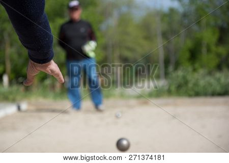Senior People Prepared To Throw The Boules Ball In A Park In Outdoor Play
