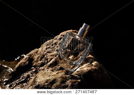 Bottle Perfume On Stone On Black Background