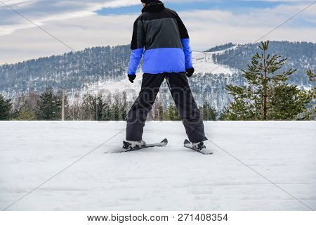 Skiing Man On Ski In Jacket Ready For Skiing With Big Ski Track In The Background