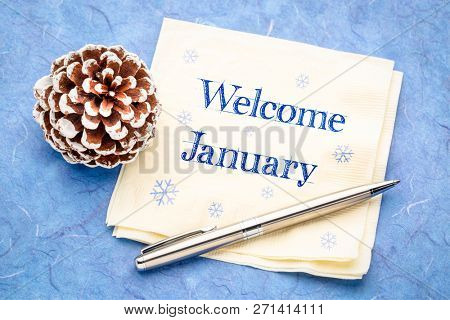 Welcome January -  handwriting on a napkin with a frosty pine cone