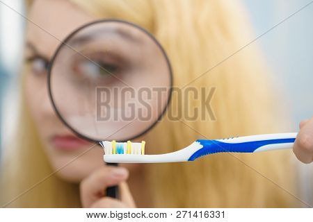 Beautiful Perfectionist Young Woman Checking Her Tooth Brush Through Manifying Loupe Glass. Hygiene,
