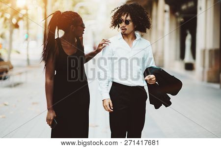 Dazzling Black Girl In The Dress And With Braids Is Calling Out To A Curly Asian Guy In Sunglasses O
