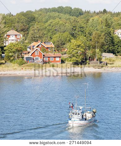 Grisslehamn, Sweden - Jul 13, 2018: Small Fishing Boat On The Blue Sea Heading Back After Taking Up 