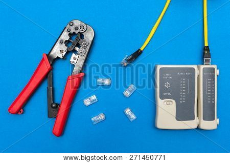 Cripmer Tool And Network Cable Tester Isolated On The Blue Background. Network Maitenance Background