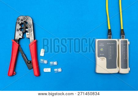 Cripmer Tool And Network Cable Tester Isolated On The Blue Background. Network Maitenance Background