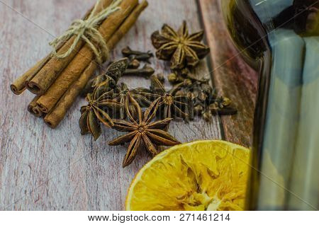 Hot Mulled Wine Drink With Lemon, Apple, Cinnamon, Anise And Other Spices In A Glass Cup Between Fir