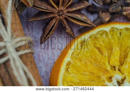 Hot Mulled Wine Drink With Lemon, Apple, Cinnamon, Anise And Other Spices In A Glass Cup Between Fir