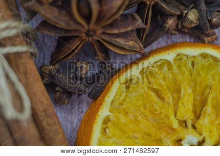 Hot Mulled Wine Drink With Lemon, Apple, Cinnamon, Anise And Other Spices In A Glass Cup Between Fir