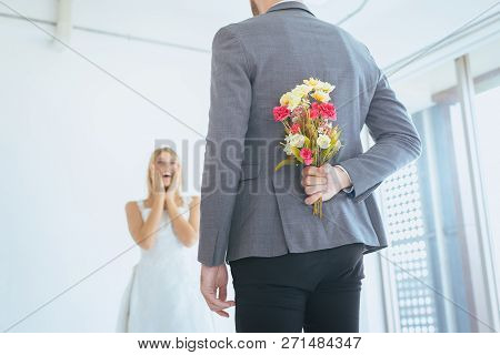 Groom Hiding Flower Behind Back In Order To Surprised  Bride On The Wedding Day,woman Positive Emoti