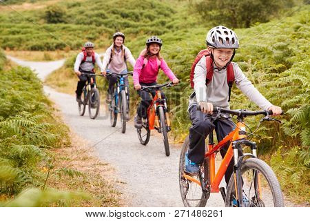 Pre-teen boy riding mountain bike with his sister and parents during a family camping trip, close up