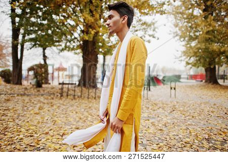 Indian Stylish Man In Yeallow Traditional Clothes With White Scarf Posed Outdoor Against Autumn Mood