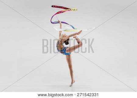 The Portrait Of Beautiful Young Brunette Woman Gymnast Training Calilisthenics Exercise With Blue Ri
