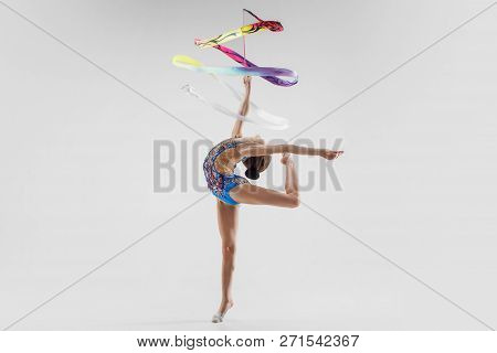The Portrait Of Beautiful Young Brunette Woman Gymnast Training Calilisthenics Exercise With Blue Ri