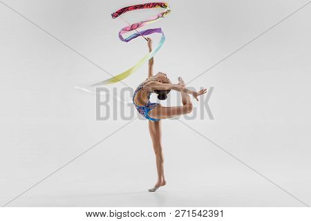 The Portrait Of Beautiful Young Brunette Woman Gymnast Training Calilisthenics Exercise With Blue Ri
