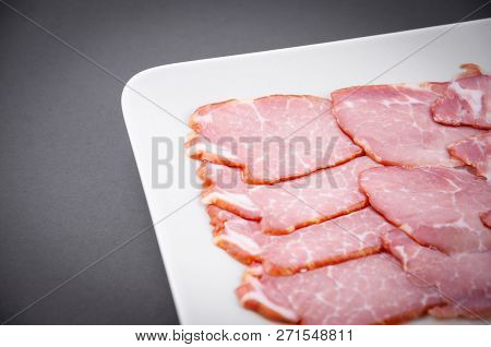 Meat Sliced In A Plate On A Dark Background Close-up