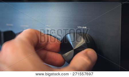 Hand Turning A Knob With Output Volume Text Written On It, With The Consequence Of A Cost Per Unit R