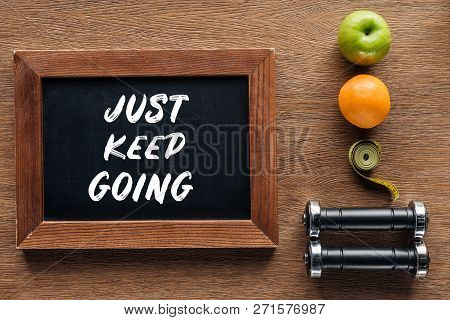 Fruits, Dumbbells, Measuring Tape And Wooden Chalk Board With Just Keep Going Quote, Dieting And Hea