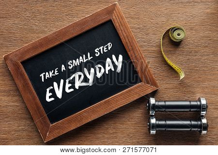 Measuring Tape, Dumbbells And Wooden Chalk Board With Take A Small Step Everyday Quote, Dieting And 