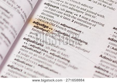 The Word Or Phrase Adjudge In A Dictionary Highlighted With Marker.