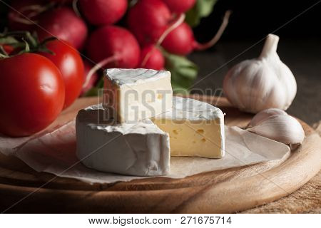 Camembert And Brie Cheese On Wooden Background With Tomatoes, Letuce And Garlic. Italian Food. Dairy