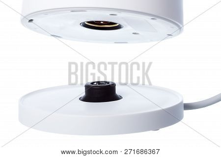Installing A White Electric Kettle On A Stand With Electrical Contacts Isolated On A White Backgroun