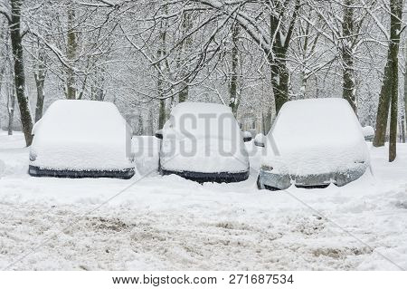Three Cars In The Parking Lot Are Covered With A Thick Layer Of Snow. Large Precipitation Concept
