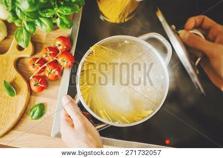 Process Of Cooking Homemade Italian Pasta. Lifestyle Background. Man Droping Spaghetti Into Boiling 