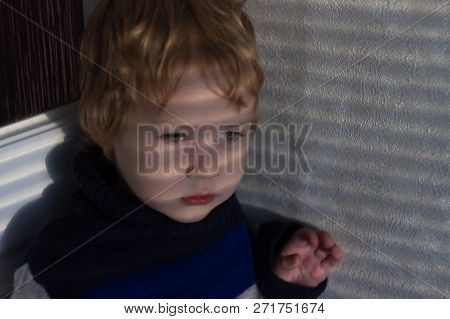 Frightened Little Boy Presses Into A Corner Looking Ahead At A Source Of Danger. The Child Is Closel