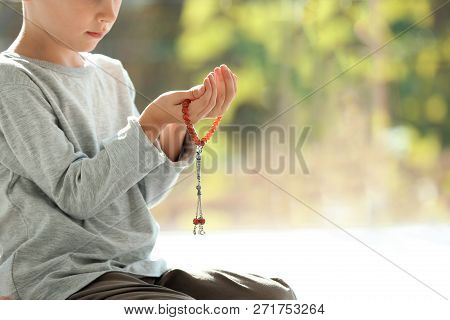 Little Muslim Boy With Misbaha Praying Indoors, Closeup. Space For Text