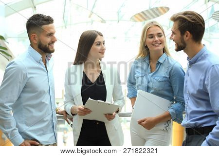 Young Modern Colleagues In Smart Casual Wear Having A Brainstorm Meeting While Standing In The Creat