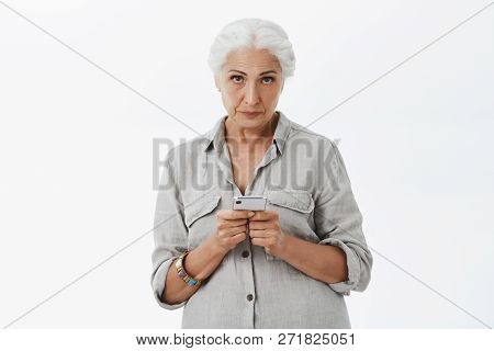 Indoor Shot Of Calm And Serious-looking Irritated Senior Woman With Gray Hair Looking With Contempt 